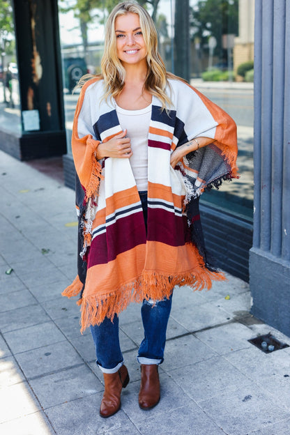 Zoe® | Follow Me Rust colored open poncho with multi colored stripes and tassel fringes