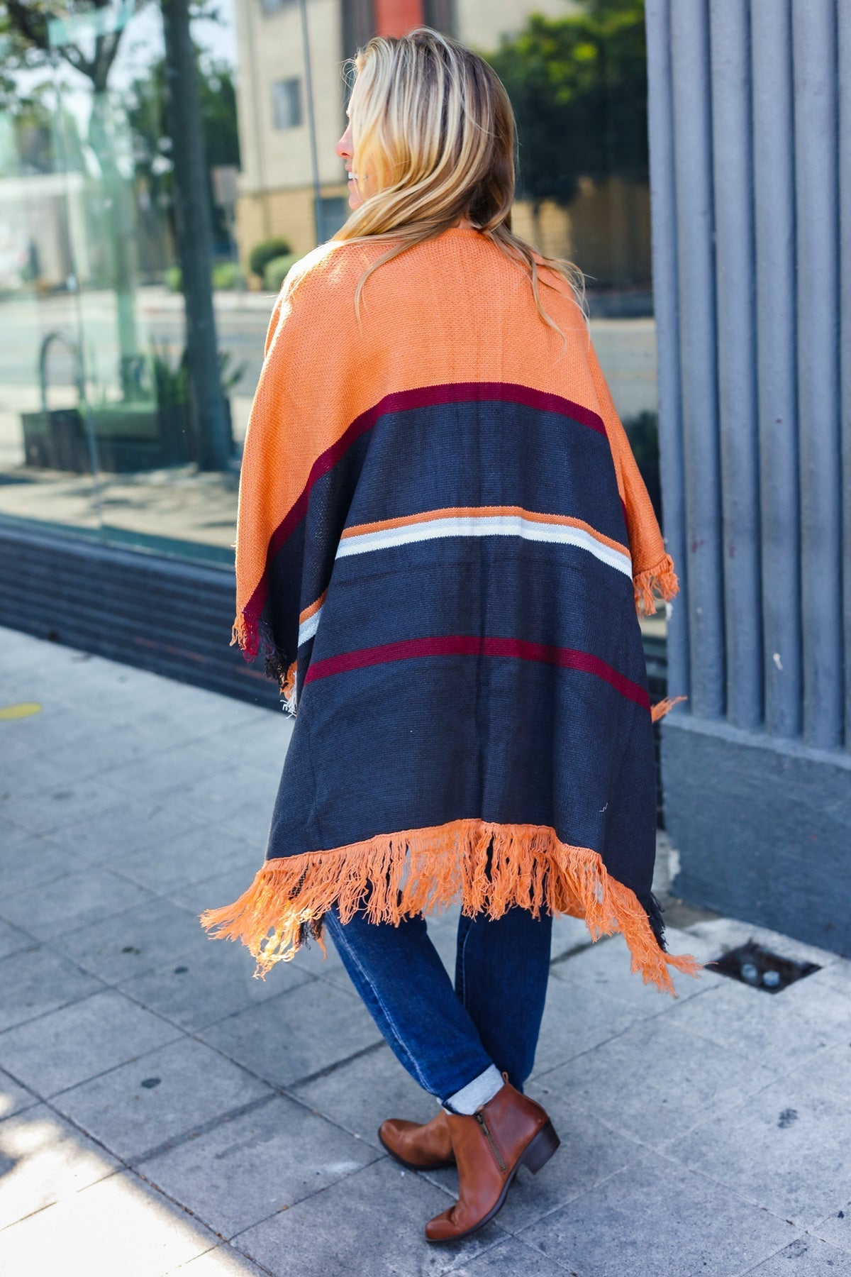 Zoe® | Follow Me Rust colored open poncho with multi colored stripes and tassel fringes